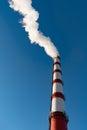 Combined heat and power plant, from the pipe goes white smoke against a background of pure blue sky