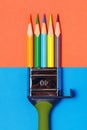 Paint brush combined with colored pencils on a two-color red-blue background Royalty Free Stock Photo