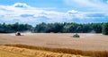 Combines at work in field during wheat harvesting