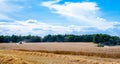 Combines at work in field during wheat harvesting Royalty Free Stock Photo