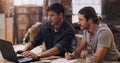 Combining expertise to ensure project success. two men discussing something on a laptop in their workshop. Royalty Free Stock Photo