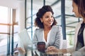 Combining their skills for success. two young businesswomen using a laptop together at work.