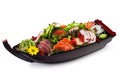 Combo Sushi sashimi: salmon, tuna, shrimp, nishin octopus, red caviar with vegetables in a wooden boat Royalty Free Stock Photo