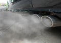Combustion fumes coming out of black car exhaust pipe, air pollution concept Royalty Free Stock Photo