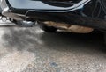 Combustion fumes coming out of black car exhaust pipe, air pollution concept Royalty Free Stock Photo