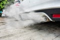 Combustion fumes coming out of white car exhaust pipe, air pollution concept Royalty Free Stock Photo