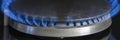 Combustion of natural gas, propane. Gas stove on a black background. Fragment of a gas kitchen stove with a blue flame