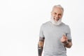 Come closer. Happy handsome old man with tattoos beckon to approach, flick finger, smiling and laughing while luring Royalty Free Stock Photo