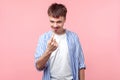 Come here! Portrait of cunning brown-haired man making beckoning gesture. isolated on pink background