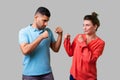 Come on let`s fight! Portrait of lovely couple in casual wear standing together. isolated on gray background Royalty Free Stock Photo