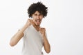 Come on let us fight. Portrait of excited self-assured arrogant male model with afro haircut, raising fists and standing