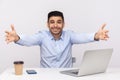 Come into my arms! Excited happy friendly businessman sitting office workplace, stretching hands to camera