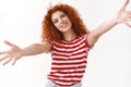 Come my arms. Friendly gorgeous ginger curly-haired caucasian girl tilting head stretch hands towards camera hug waiting