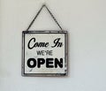 Come in we are open, black and white retro sign on white wall of a store. Royalty Free Stock Photo