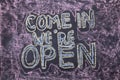 Come in we`re open. Chalk lettering on blackboard. Multi colored inscription Royalty Free Stock Photo