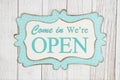 Come in we`re open text on a retro tin polka dot picture sign