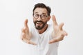 Come to me dear. Portrait of charming thrilled and happy mature male model with beard in trendy glasses and casual t Royalty Free Stock Photo