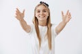 Come to me in my arms cutie. Portrait of tender attractive and joyful young woman with fair hair in headband pulling Royalty Free Stock Photo