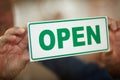 Come on in. an unidentifiable business owner holding up and open sign in the door of a coffee shop. Royalty Free Stock Photo