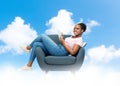 happy young woman in armchair writing to notebook Royalty Free Stock Photo