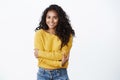 Comfort, romance and coziness concept. Cheerful lovely african-american girl in yellow sweater hugging herself