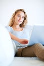 Comfort and worldwide connectivity. A pretty young woman working on her laptop at home. Royalty Free Stock Photo