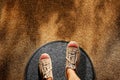 Comfort Zone Concept. Male on Sneaker Shoes Steps over Circle Line to Outside Bound, Top View, Grunge Dirty Concrete Floor with