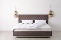 Comfortable bed with new mattress near wall in room. Royalty Free Stock Photo