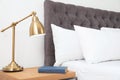 Comfortable bed and nightstand in modern room Royalty Free Stock Photo