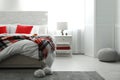 Comfortable bed with warm checkered plaid in stylish room interior Royalty Free Stock Photo