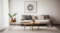 Comfortable beige sofa with pillows and blanket against white classic wall with art poster. Beautiful and cosy mid-century style