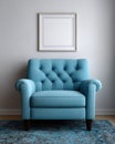 Comfortable blue armchair with picture frame on wall. Royalty Free Stock Photo