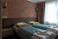 Empty hotel room with beds near red brick wall and window Royalty Free Stock Photo