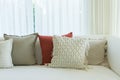 Gray sofa with cushions near windowComfortable couch with orange and red pillow in spacious living room interior Royalty Free Stock Photo