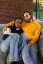 Comfortable Embrace: Multiethnic Couple Relaxing on Couch with Warmth and Style Royalty Free Stock Photo
