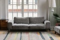 Comfortable grey couch standing in modern empty living room Royalty Free Stock Photo