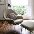Comfortable light green armchair by window in light filled room