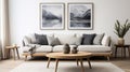 Comfortable light sofa with pillows and blanket against white classic wall with art posters. Beautiful and cosy mid-century style