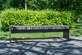 Comfortable in metal and wooden material bench in city park.