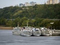 Comfortable multi-deck tourist boats are moored at the pier. Cruise ships are waiting for passengers. Water transport