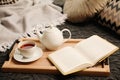 Comfortable place for reading with open book and hot tea Royalty Free Stock Photo