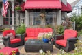 Comfortable red outdoor furniture outside of a b&b in New England with window and awning behind Royalty Free Stock Photo