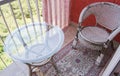 A comfortable seating area on the balcony with a rattan wicker chair, a transparent glass table and a rug, a home Royalty Free Stock Photo