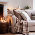 Comfortable shite sofa with cushions and plaid near side table with burning candles. Scandinavian interior design