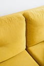 Comfortable sofa with mustard velvet textile, closeup