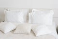 Comfortable soft pillows on the bed. Close-up white bedding sheets and pillow on light wall room background. Fresh bed Royalty Free Stock Photo