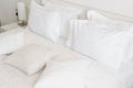 Comfortable soft pillows on the bed. Close-up white bedding sheets and pillow on light wall room background. Fresh bed Royalty Free Stock Photo