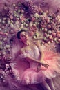 Young woman in pink ballet tutu surrounded by flowers