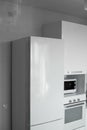 Comfortable white kitchen with a white lacquered facades. Modern kitchen clean interior design. Refrigerator, kitchen