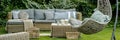 Wicker garden furniture with grey pillows in beautif